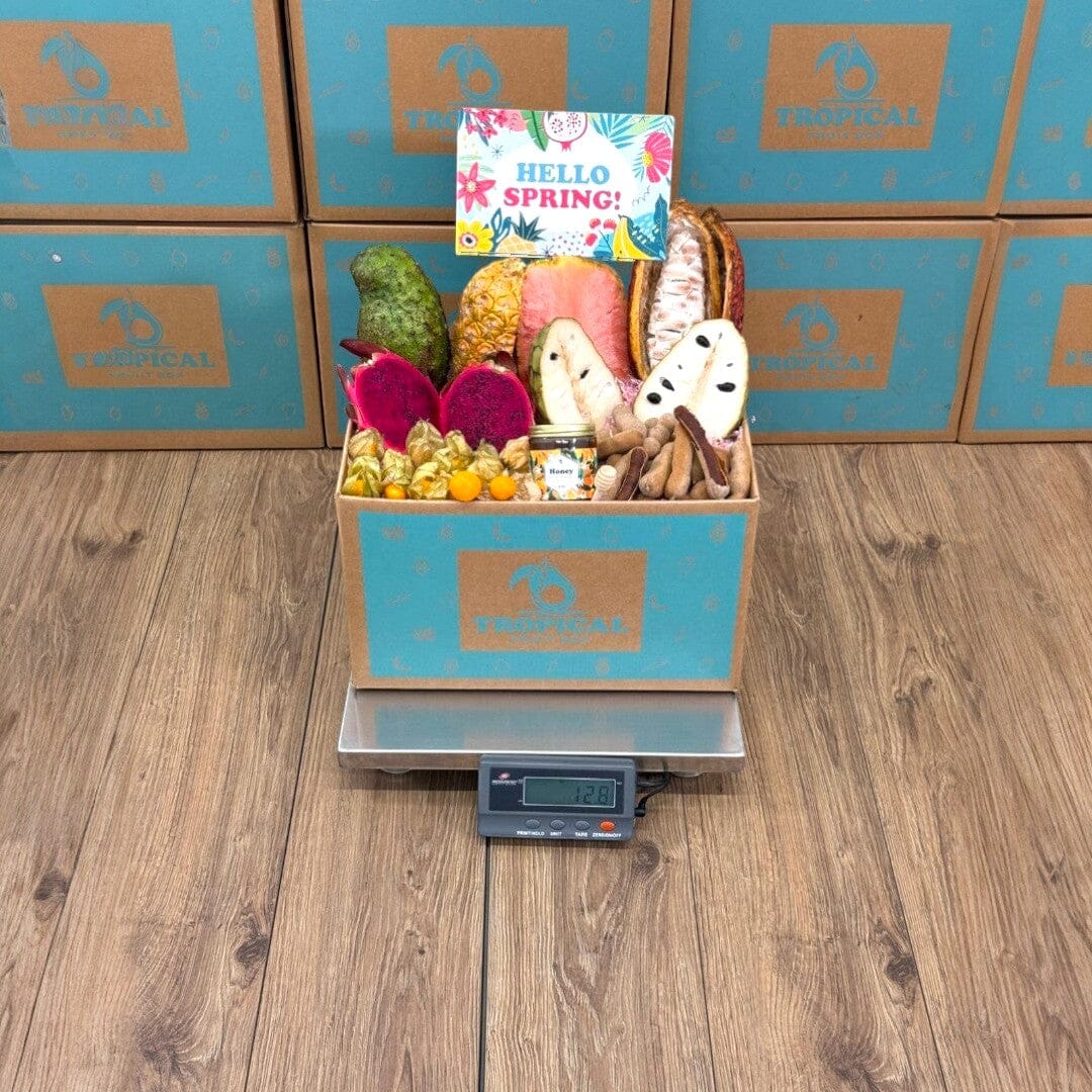 Tropical Fruit Box exotic fruit assortment with dragon fruit, soursop, pineapple, cherimoya, lychee, tamarind, and honey.
