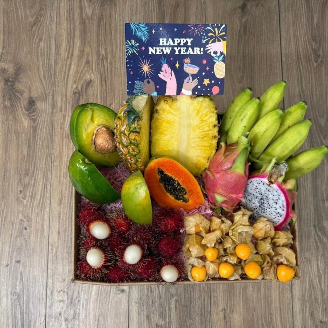 Tropical Fruit Box assortment featuring mango, pineapple, avocado, dragon fruit, bananas, rambutan, and golden berries.