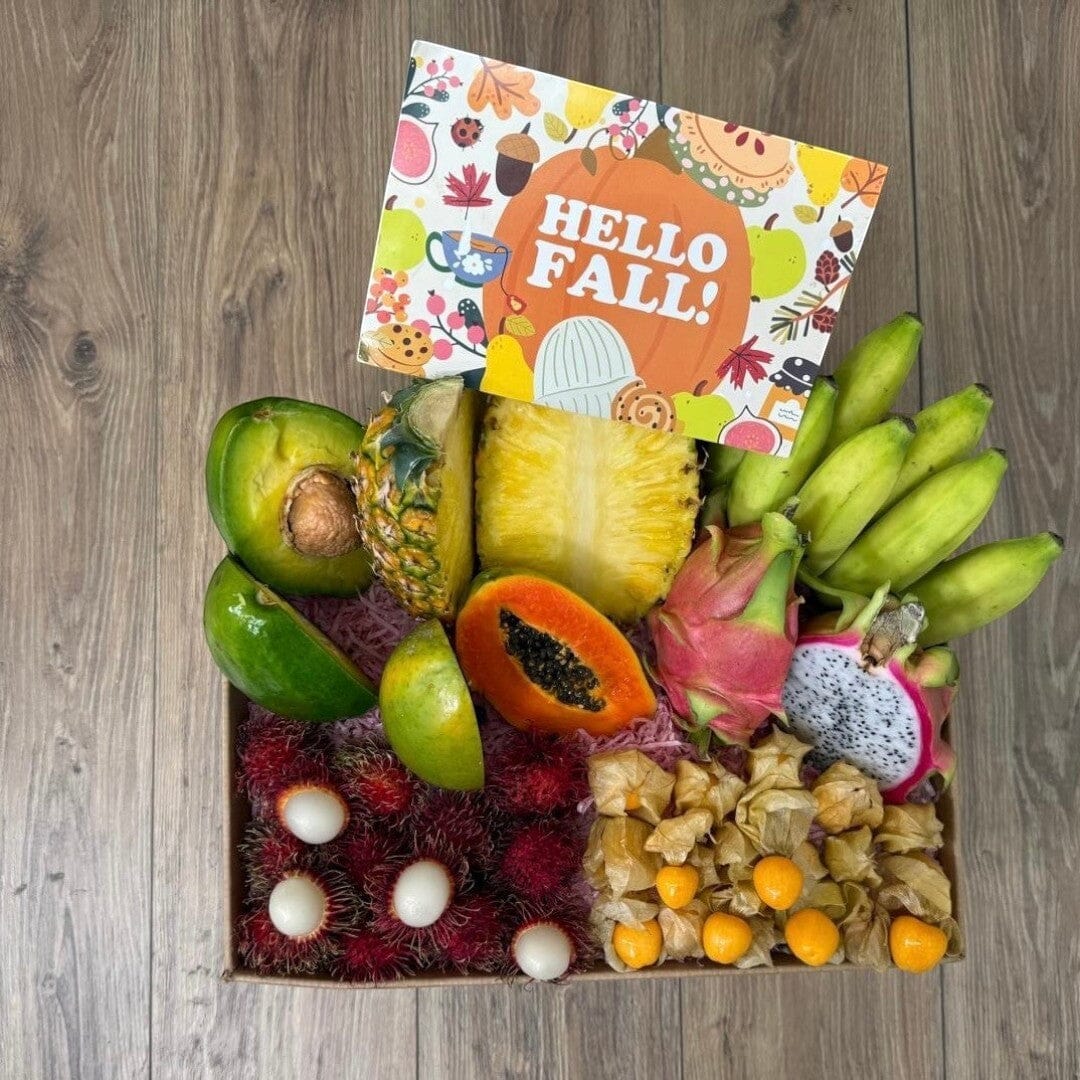 Tropical Fruit Box assorted exotic fruits including pineapple, dragon fruit, papaya, and bananas with a Hello Fall card
