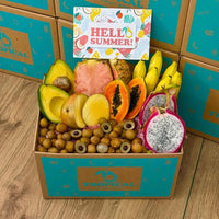 Thumbnail for Tropical Fruit Box assortment featuring pink pineapple, dragon fruit, mango, avocado, and bananas in a branded box.