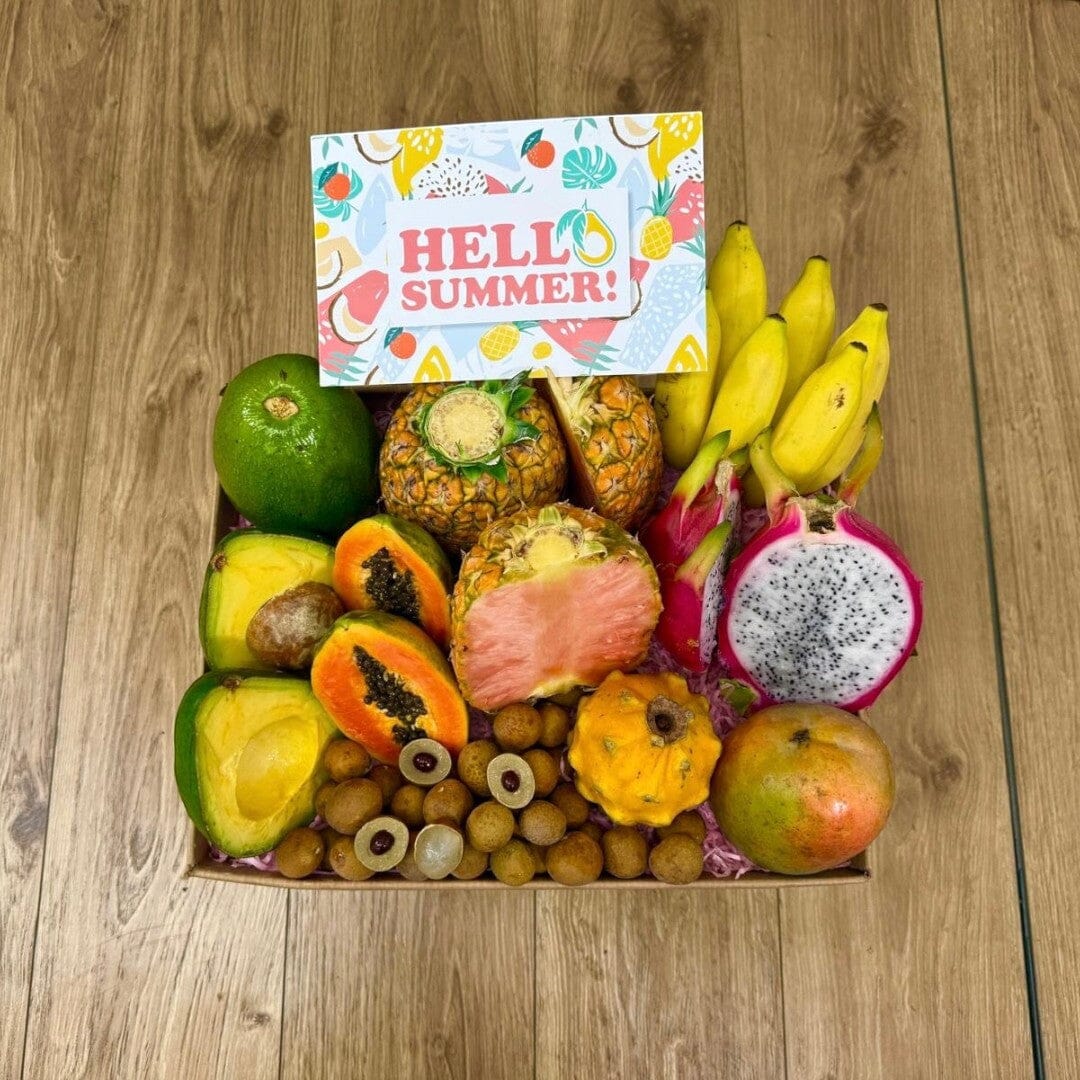 Tropical Fruit Box assortment featuring pink pineapple, dragon fruit, mangoes, and avocados in a gift box.