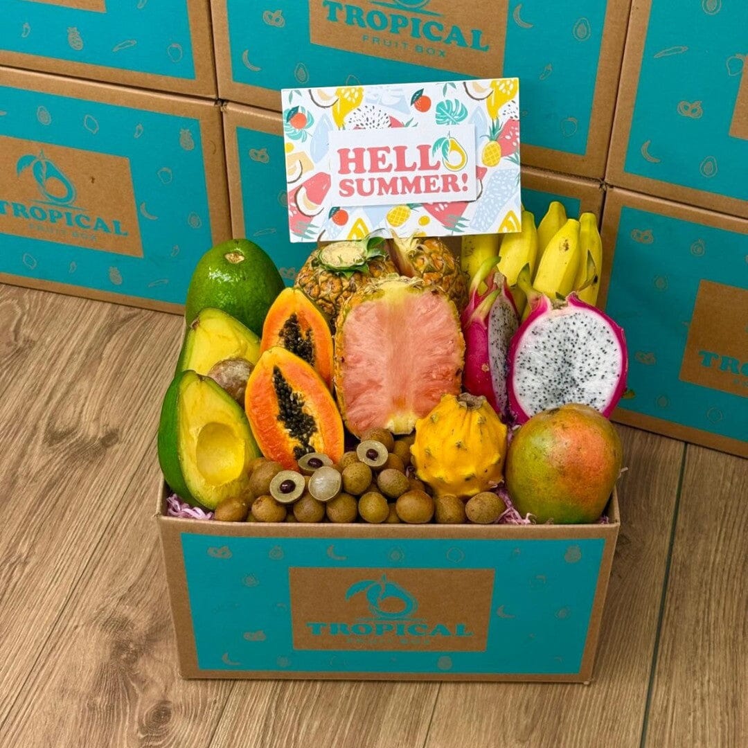 Tropical Fruit Box filled with pink pineapple, mango, dragon fruit, avocado, and bananas with a Hello Summer card