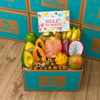 Thumbnail for Tropical Fruit Box filled with pink pineapple, mango, dragon fruit, avocado, and bananas with a Hello Summer card