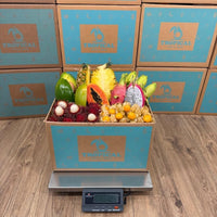 Thumbnail for Tropical Fruit Box assortment featuring mango, pineapple, dragon fruit, and papaya in a branded shipping box on a scale