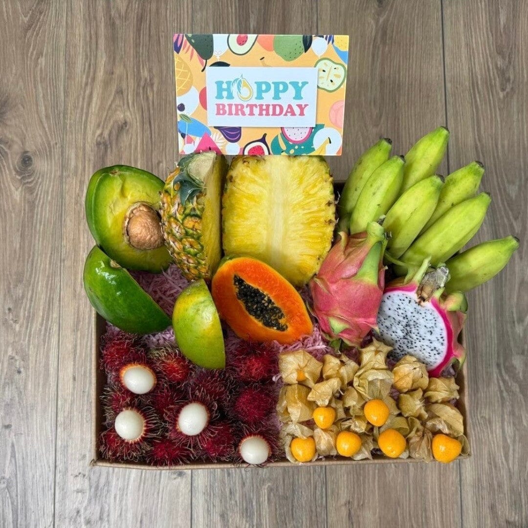 Tropical Fruit Box gift set featuring mango, pineapple, avocado, dragon fruit, bananas, and rambutan with birthday card