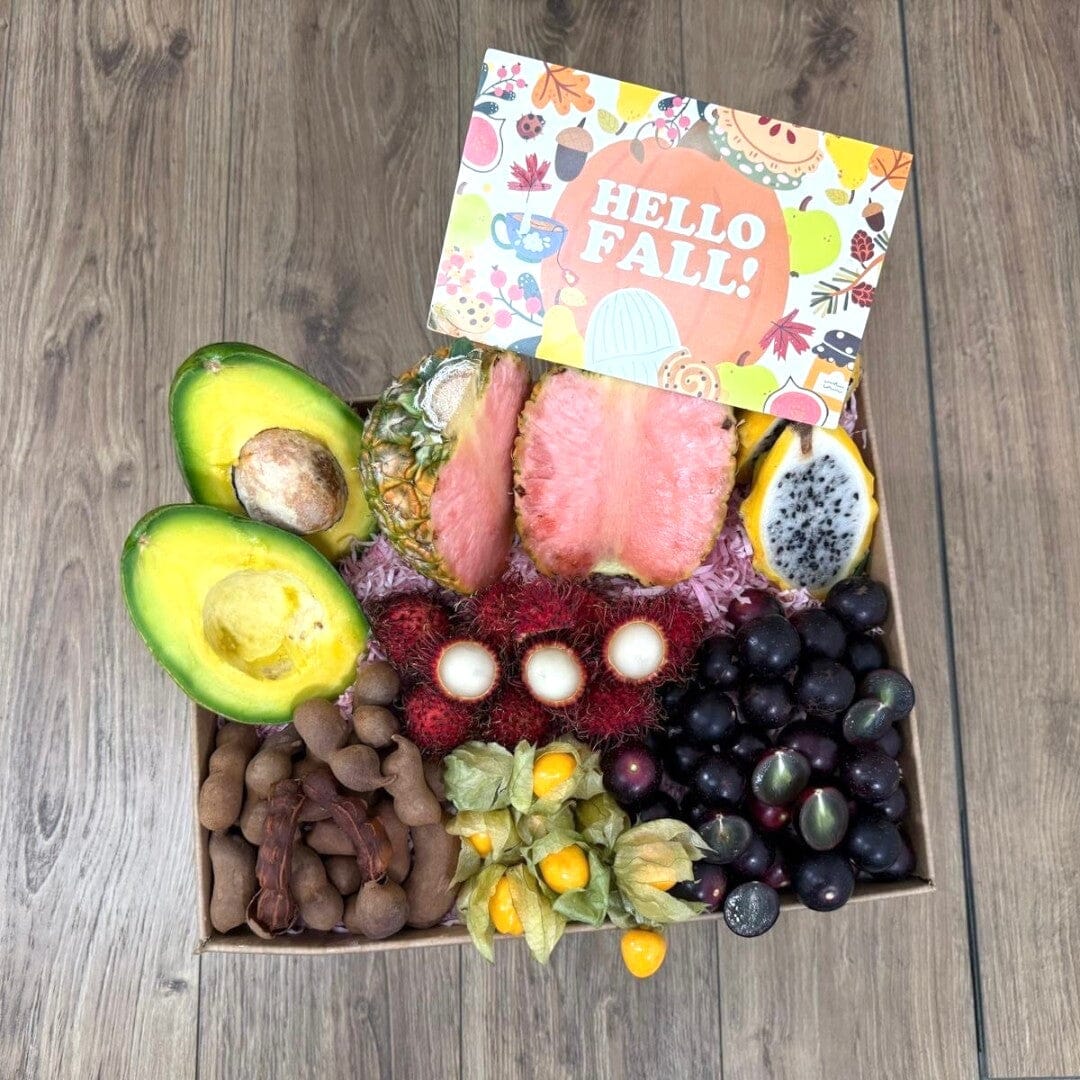 Tropical Fruit Box Fall Feast gift box featuring pink pineapple, avocado, longans, tamarind, and golden berries.