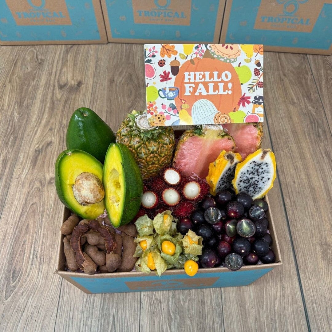 Tropical Fruit Box Fall Feast gift box featuring pink pineapple, avocado, dragon fruit, and golden berries.