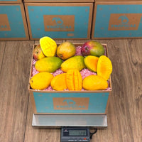 Thumbnail for Tropical Fruit Box offers a 12lb box of 12-15 fresh, ripe mangoes in various colors including yellow, green, and red.