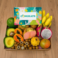 Thumbnail for Tropical Fruit Box gift set featuring pink pineapple, dragon fruit, mangoes, and bananas with a Congrats card.