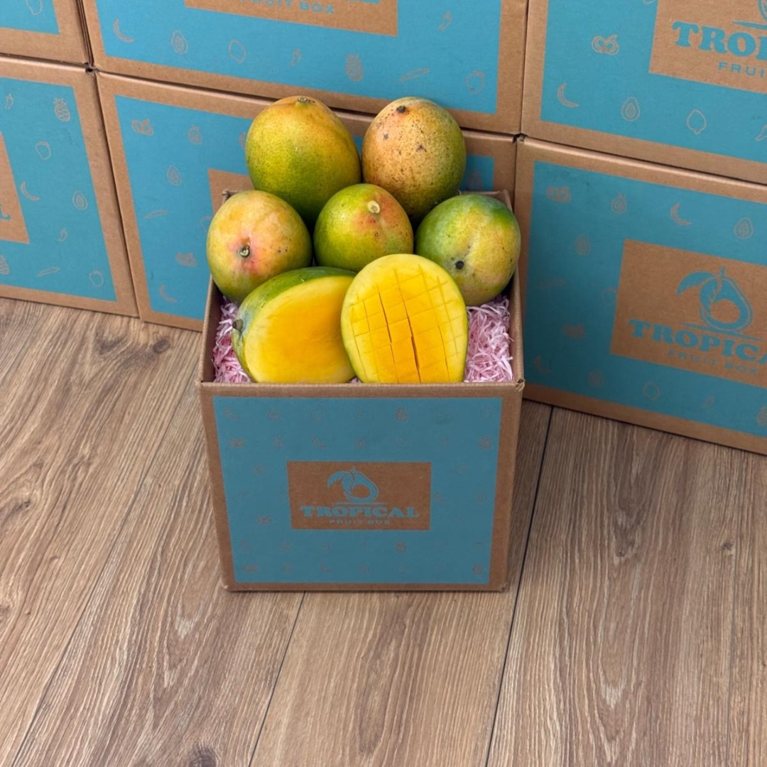 Tropical Fruit Box Kent mangoes in a branded cardboard crate with one sliced mango showing juicy orange flesh.