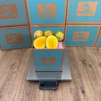 Thumbnail for Tropical Fruit Box Kent mangoes in a branded cardboard box on a digital scale with sliced fruit showing orange flesh