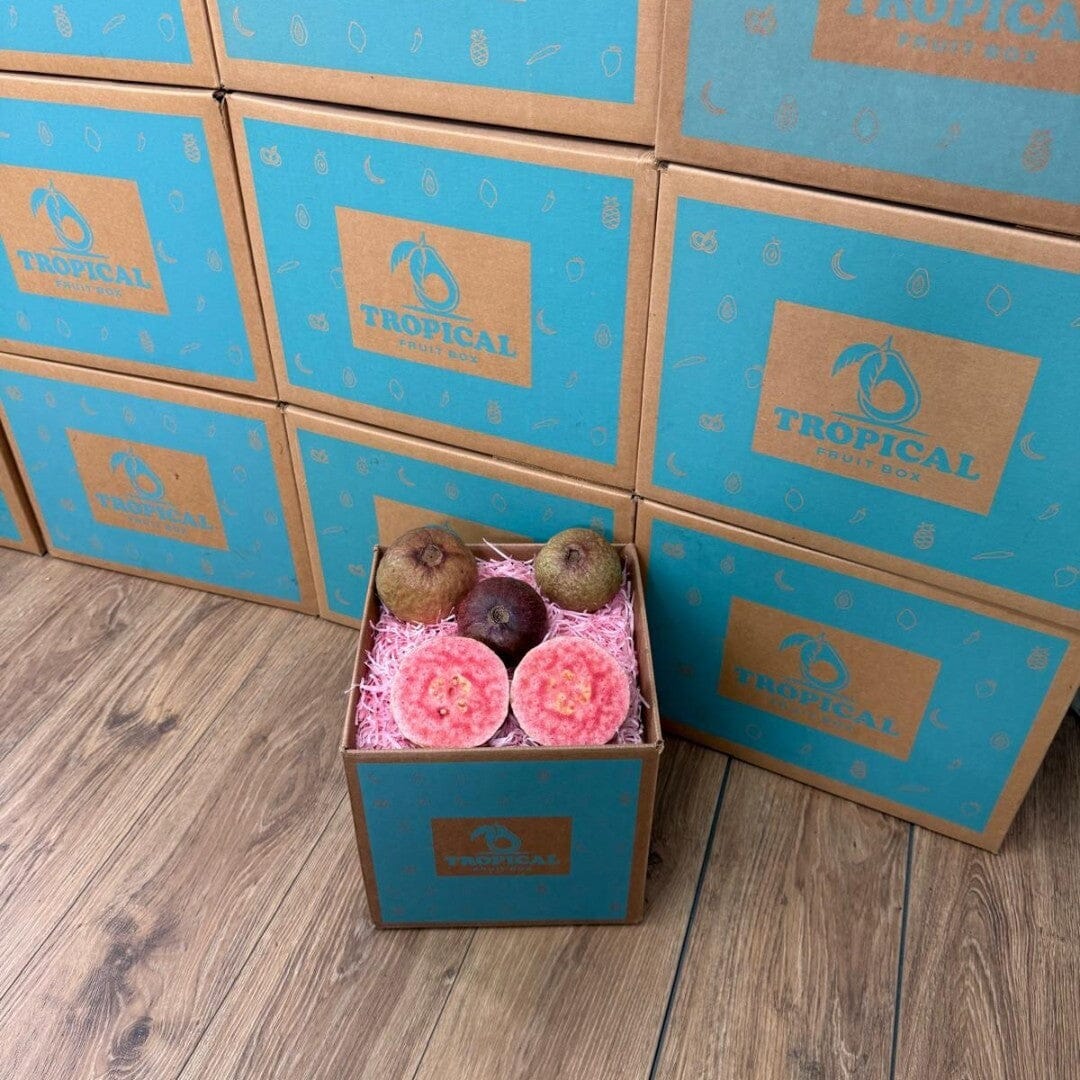 Tropical Fruit Box purple guavas, whole and halved, showcasing vibrant pink flesh and skin.