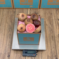 Thumbnail for Tropical Fruit Box purple guava fruit with vibrant pink flesh, whole and sliced, in a box on a scale.