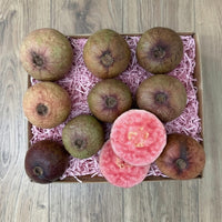 Thumbnail for Tropical Fruit Box box of 10 purple guavas, some whole and some sliced, revealing pink flesh.