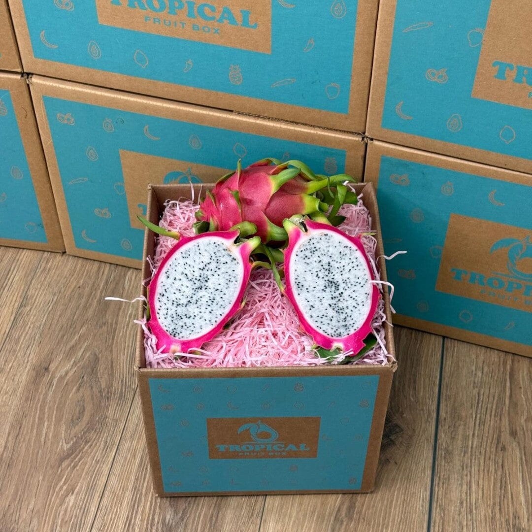 Tropical Fruit Box red dragon fruit, white flesh with black seeds, vibrant pink skin, presented in a box with pink shred.