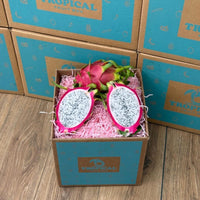 Thumbnail for Tropical Fruit Box red dragon fruit, white flesh with black seeds, vibrant pink skin, presented in a box with pink shred.