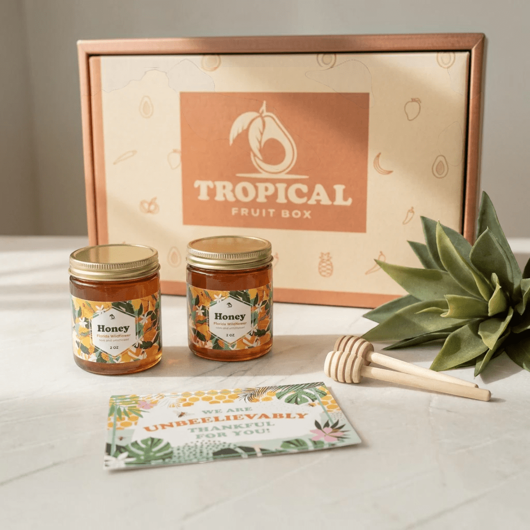 Tropical Fruit Box honey gift set featuring two jars of Florida Wildflower honey, honey dippers, and a thank you card.