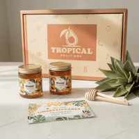 Thumbnail for Tropical Fruit Box honey gift set featuring two jars of Florida Wildflower honey, honey dippers, and a thank you card.